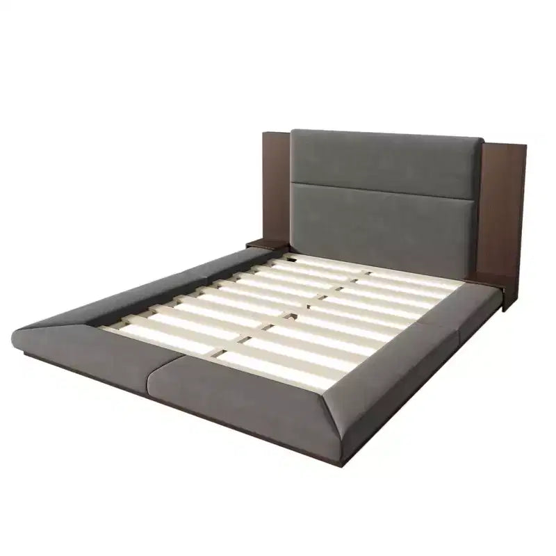 Letto imbottito a piattaforma, a filo pavimento, con testiera estesa in legno e mensole comodino integrate