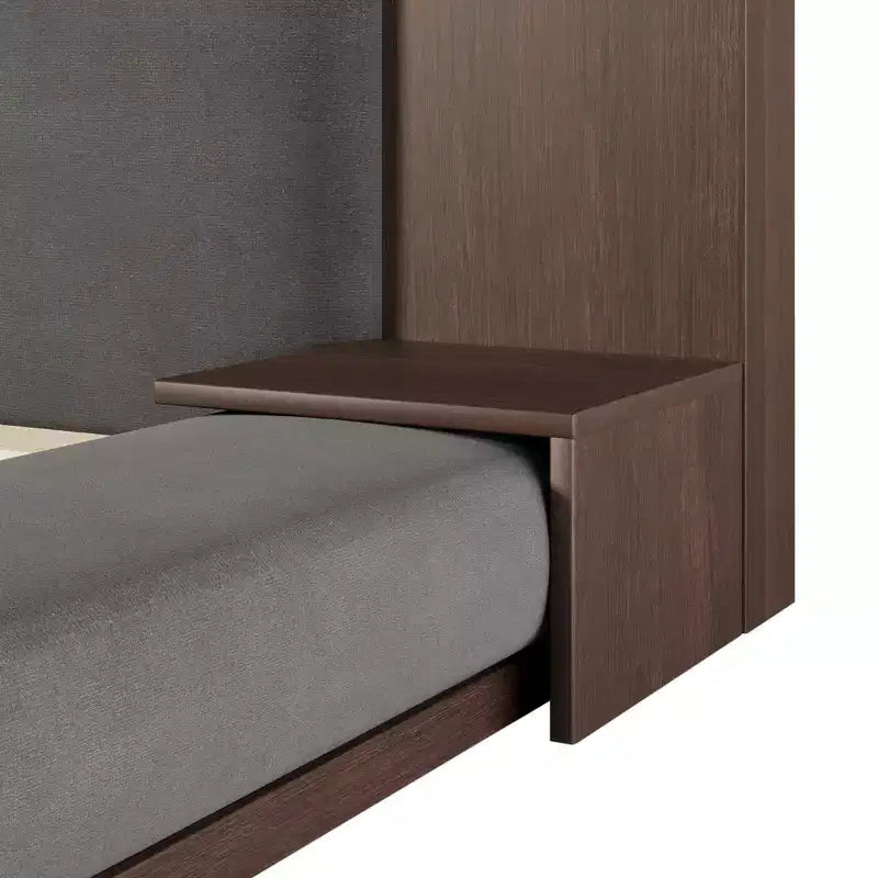 Letto imbottito a piattaforma, a filo pavimento, con testiera estesa in legno e mensole comodino integrate